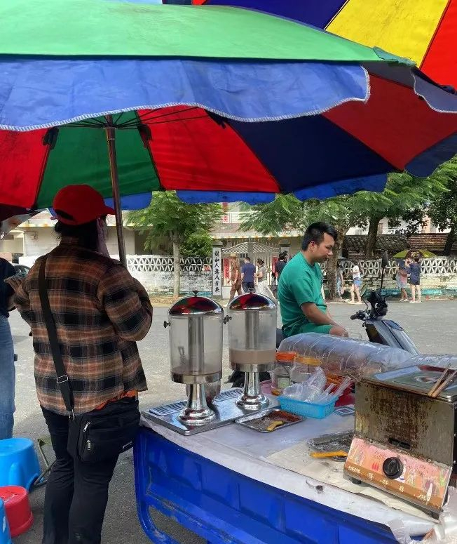 ▲全红婵夺冠后，家门口迎来不少游客，也吸引着卖烤肠、饮料等商贩在她家门口摆摊