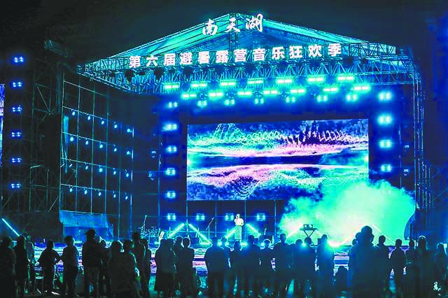     7月31日，丰都南天湖旅游度假区，游客正在湖边草坪上享受音乐会。