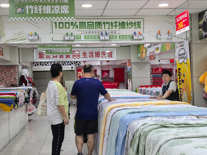 消费者在新街口百货纺织厅选购竹纤维凉席。（中国商报记者 于佳鑫/摄）