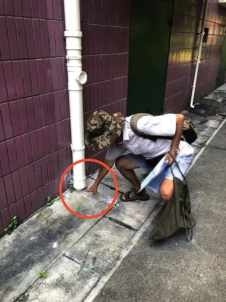     ▲鲁先生指出雨水管道下厨房污水流过地面的痕迹。    本报记者陆增安 摄