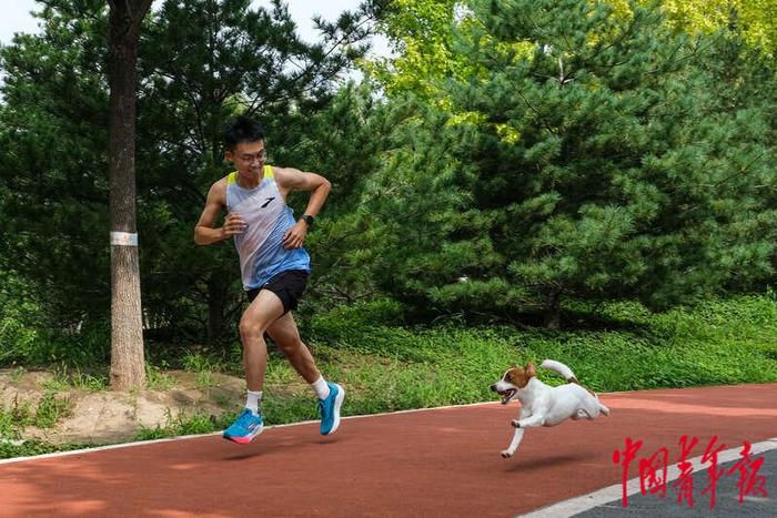 7月27日，北京丽泽公园，杨浩冰和家中的小狗“六一”一起跑步。王藜静/摄