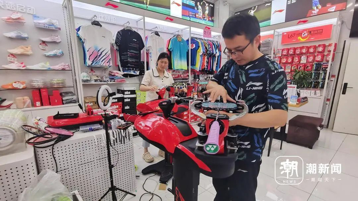 8月8日晚上，杭州余杭区一家店铺内，穿线师邵宗远（右一）正在为羽毛球拍换线。陶景成 摄