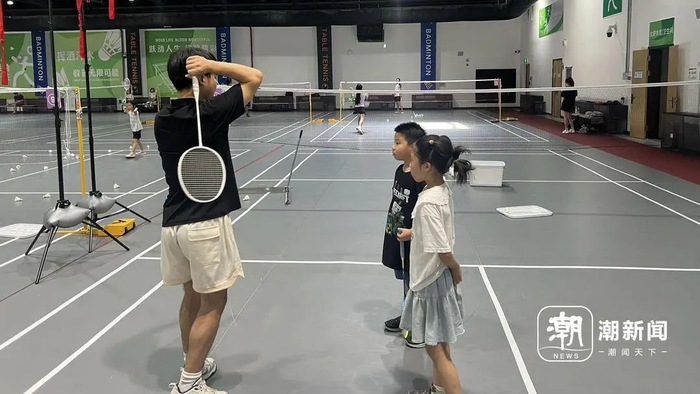 8月10日上午，杭州拱墅区一家羽毛球场馆内，教练正在挥拍培训教导羽毛球学员。记者 吴越 摄