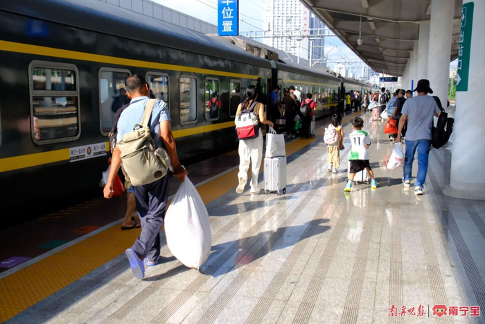 旅客提着行李准备上火车。