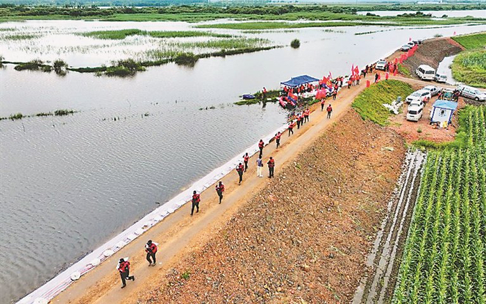 公安突击队员对堤防进行抢险加固。 本报记者 张澍摄