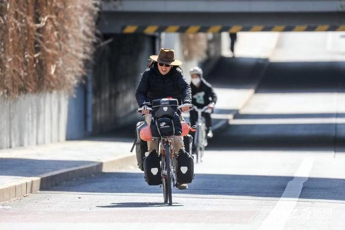 ▲朱志文在骑行 Zhu Zhiwen is riding a bike.  