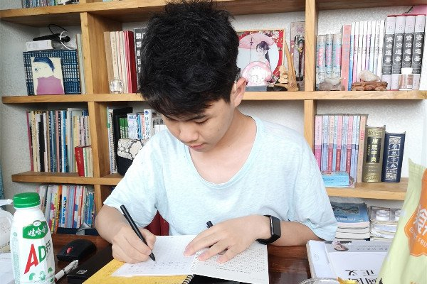 杨骐嘉在学习,他左耳做了人工耳蜗,右耳佩戴助听器。受访者供图