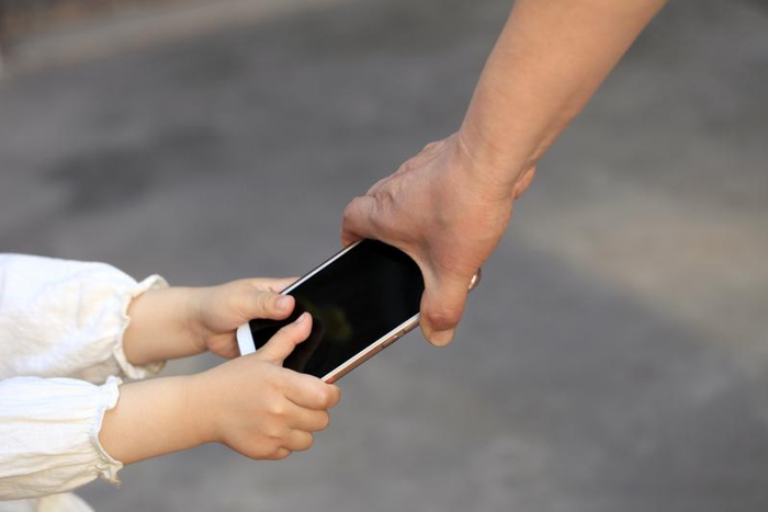 ▲爱玩手机沉迷网络游戏的儿童和家长争夺手机。图/IC photo