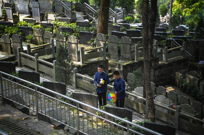 ▲陵园工作人员代客祭扫，为一位逝者擦拭墓碑、送上鲜花。记者 郑宇 摄/视觉重庆