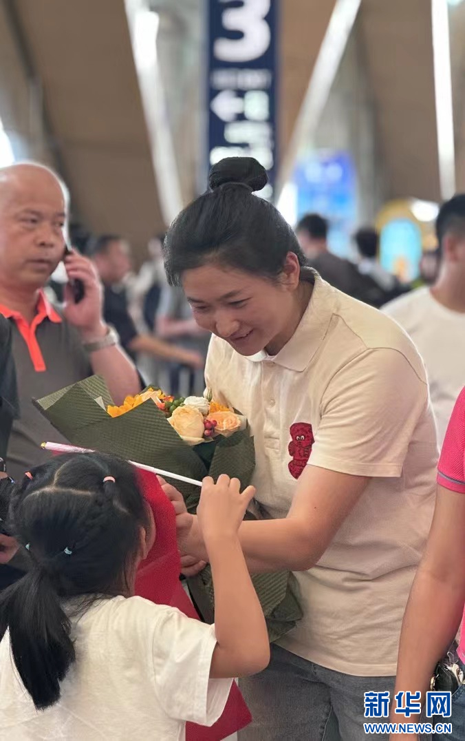 刘浩的女儿迫不及待想与爸爸见面，刘浩的妻子秦丽芝安抚着急的女儿（8月15日摄）。新华网 柴静 摄