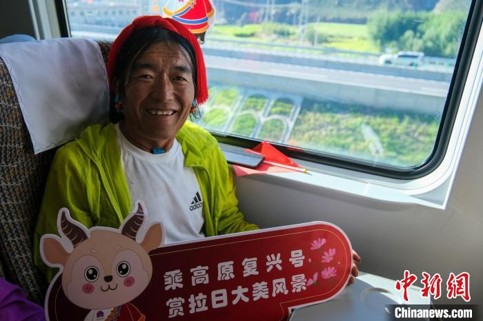 　　图为8月16日，西藏日喀则定日县扎果乡农牧民米玛乘坐高原复兴号，窗外为拉日高等级公路。中新社记者 江飞波 摄
