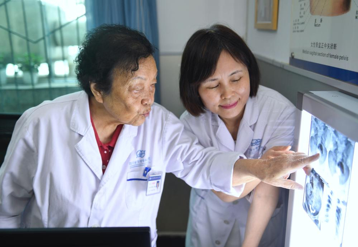 2024年8月2日，谢蜀祥（左）在四川省生殖健康研究中心附属专科医院与同事讨论患者治疗方案。