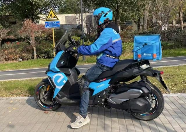 朱先生和他饿了么涂装的摩托车。受访者供图