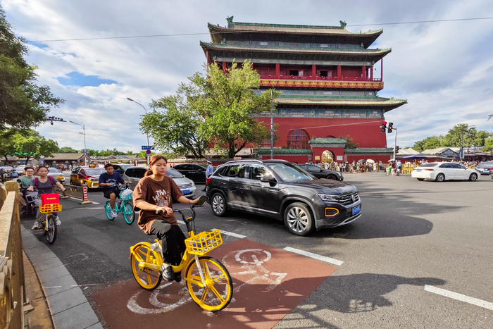 游客在中轴线鼓楼周边骑车游玩。邓伟摄