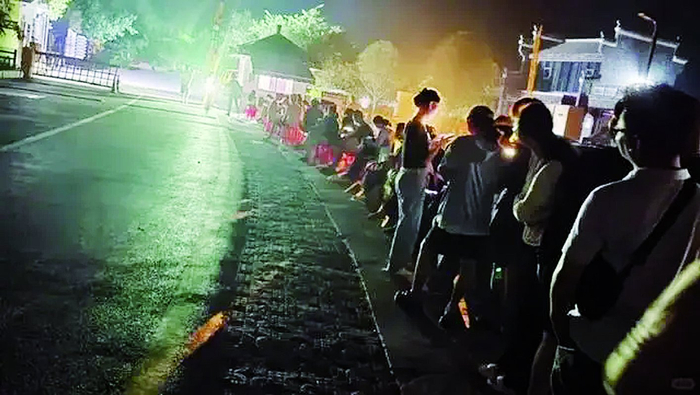     广西桂林遇龙河景区，凌晨等待坐竹筏的游客排起了长龙。网络图