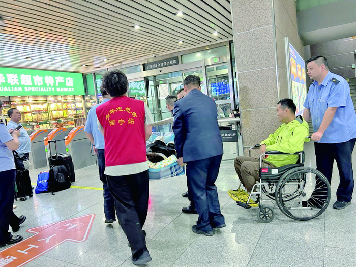 众人合力护送受伤旅客转乘。西宁火车站供图