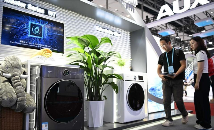 第135届广交会上，参观者在智能家电展区了解洗衣机产品。新华社记者邓华摄