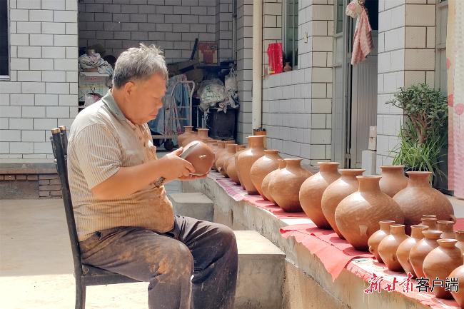 阎建林正在制作彩陶。