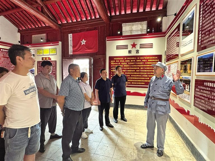 8月19日，丹凤县庾岭镇鄂豫皖省委常委会议旧址内，杨青山（右）为游客讲解。 记者 文超摄