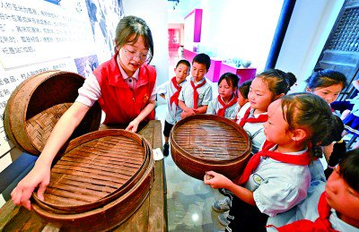     四川省眉山市仁寿县方家镇哨楼村村史馆，方家镇小学的学生正在了解传统农业器具。潘帅摄/光明图片