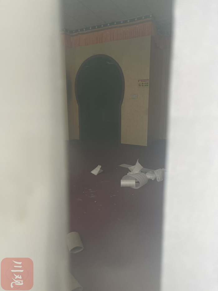 从玻璃向内看，视频中曝光的玉石店已人去楼空。  王子玫 摄