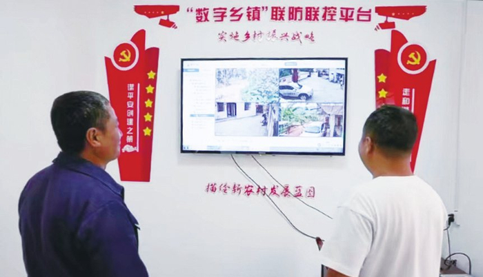  村干部查看交通要道监控影像
