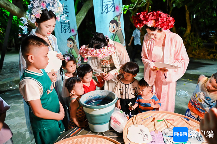 　　孩子们参与画团扇活动。记者 梁振文 摄