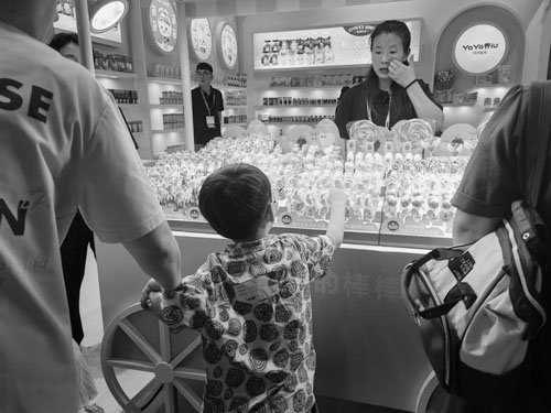 图为消费者在了解“不伤牙的棒棒糖”。