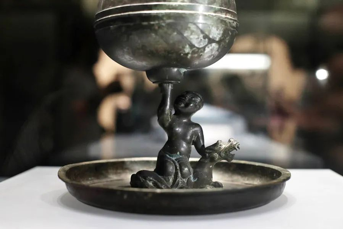 不同于一般的博山炉，其底盘有一骑兽力士脚踩野兽，托举着博山炉。