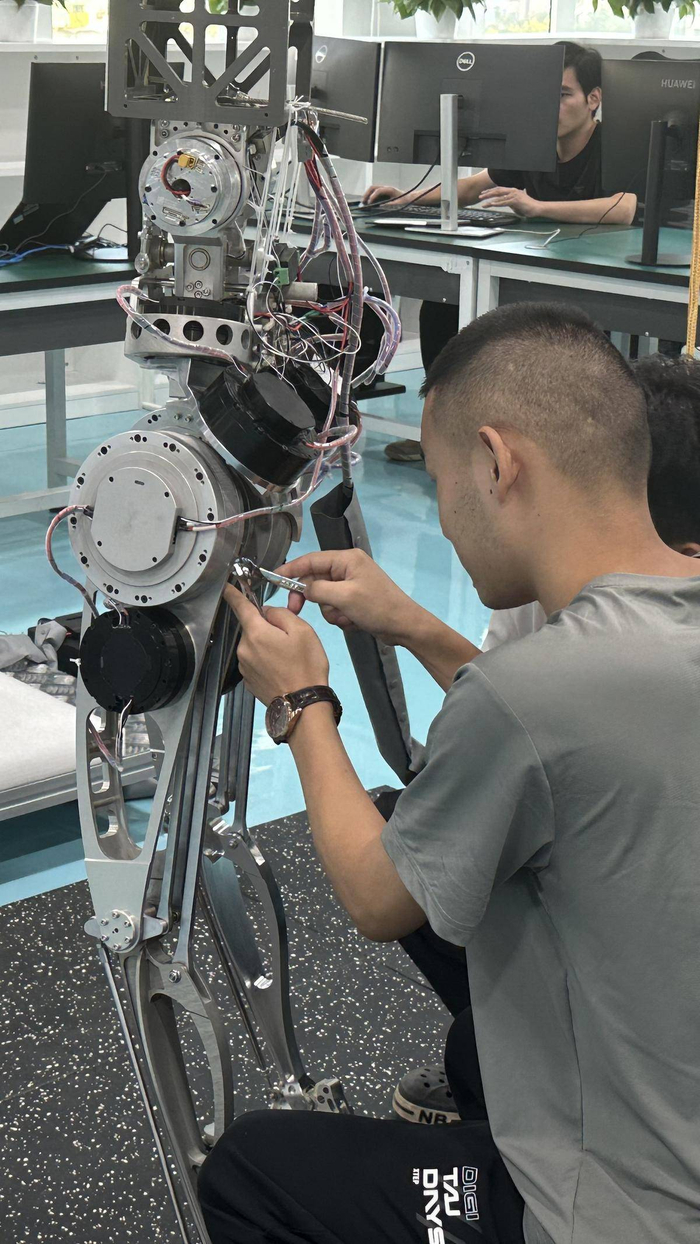 格蓝若公司工作人员正在给人形机器人进行行走测试。（湖北日报全媒记者 刘宇 摄）