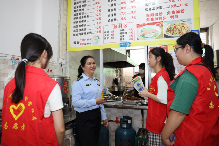 志愿者在食品经营户处开展志愿活动。