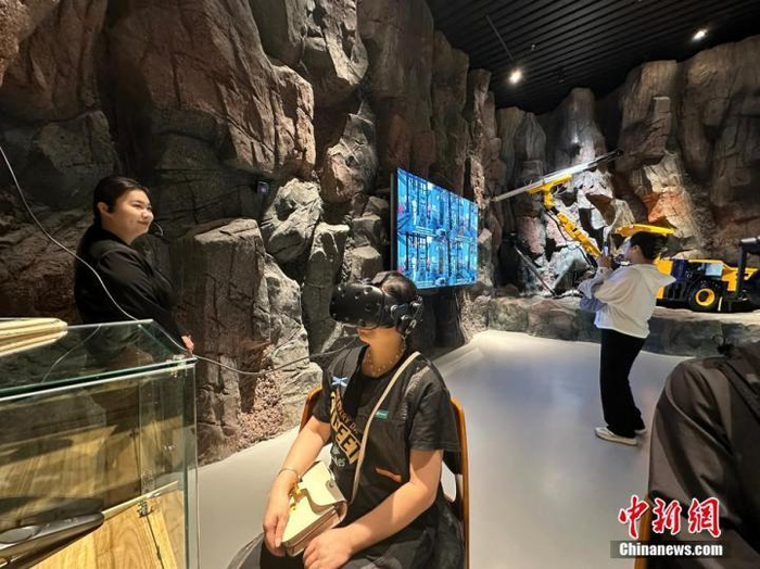 图为游客在馆内用VR互动装置体验采矿全流程。王牧雨摄