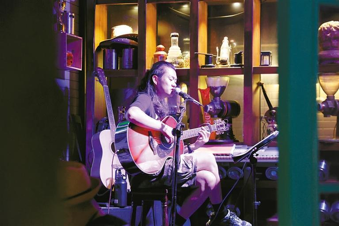 德福巷一位酒吧歌手在弹唱 记者 谢伟 摄