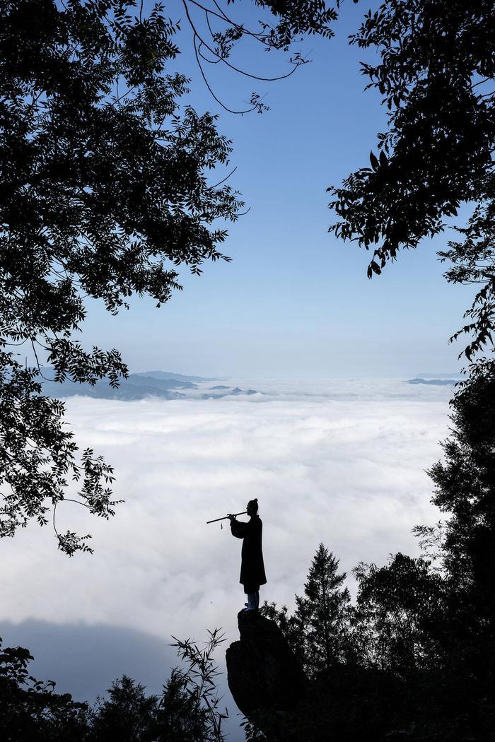 8月19日，在白马山天马峰顶，波兰人达瑞兹面对山谷间的云海练习洞箫。