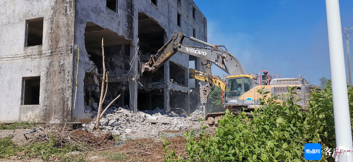 作业机械在对项目内已完成征收的楼房进行拆除。记者 王康景 摄