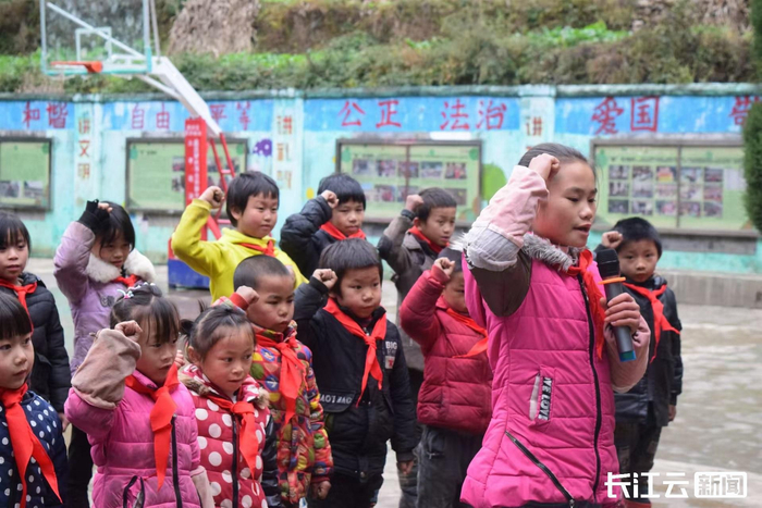 △2017年，时读六年级的龙海芬在支教老师曹媛媛的鼓励下，站在队列前主持升旗仪式。