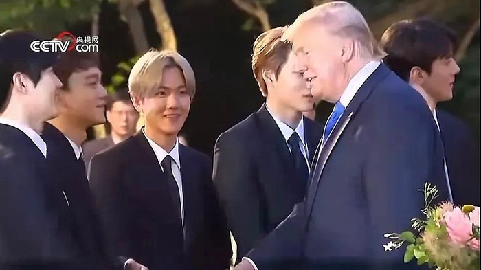 特朗普与EXO成员握手 截图来源：央视网