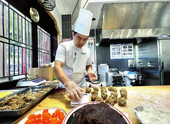 万国传统糕点制作技艺第五代传承人黄日强在制作传统手工月饼。记者 潘浩 摄