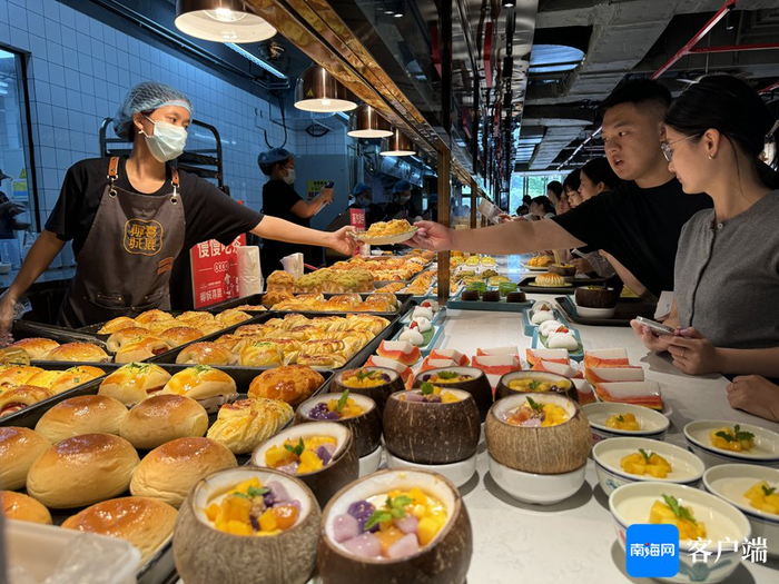 美食档口的各类糕点、小吃琳琅满目，食客们拿着点餐的卡牌挑选着自己喜欢的美食。记者 郑光平 摄
