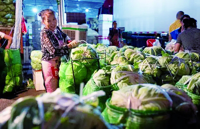     8月28日凌晨，九龙坡区蔬菜批发市场，卖家帮助客户将蔬菜打包。据新重庆-重庆日报