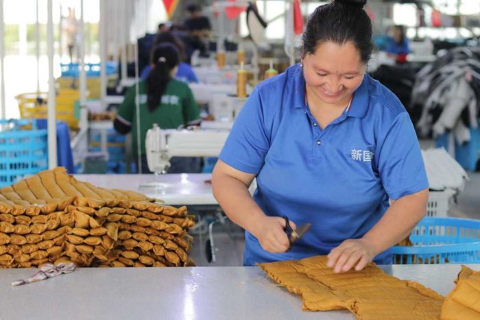 在阿克塔什镇就业产业园的服装生产车间内，左热汗·色达麦提正熟练地裁剪羽绒马甲。本报记者韦佳玥摄
