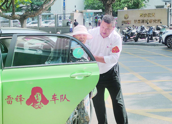 的哥王锋利扶老人上车。