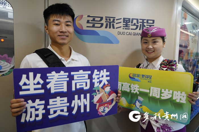 列车工作人员和旅客庆祝贵南高铁全线开通运营一周年