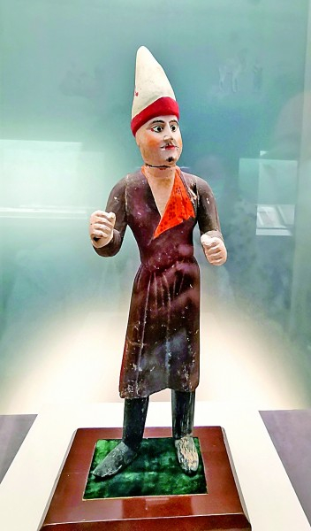 　　图为新疆出土的唐代彩绘驼夫木俑 光明日报记者李韵摄/光明图片