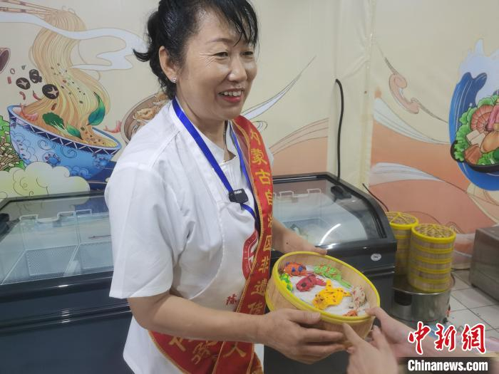 图为贾银凤在包头金街展示的武川石磨莜面制作技艺。　　中新网记者 李爱平 摄