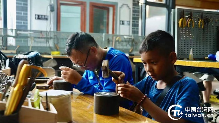 张轩恺和父亲在滇体验非物质文化遗产鹤庆银器锻制。 （中国台湾网记者 严少楷 摄）