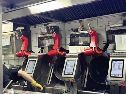 图为工作人员在清洗炒菜机器人。 黄芷凌 摄