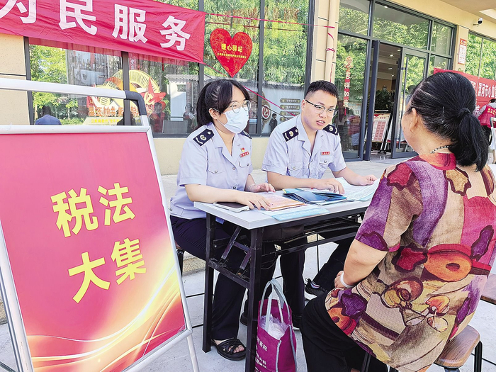 漯河市召陵区税务局税费网格员在漓江路社区开展“税法大集”活动，为居民讲解社保政策。夏长虹 摄