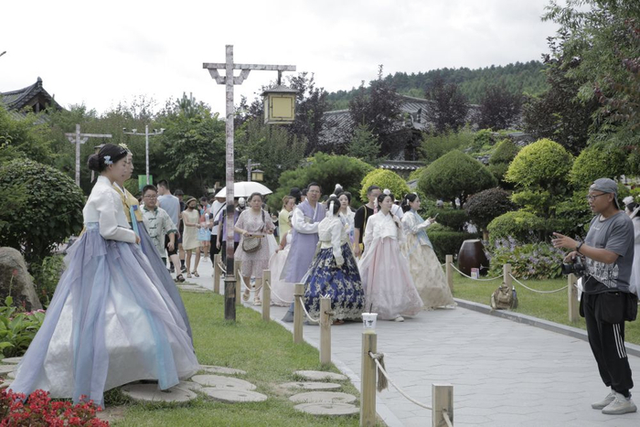   8月28日，游客身着朝鲜族服饰在中国朝鲜族民俗园打卡拍照。（受访者供图）