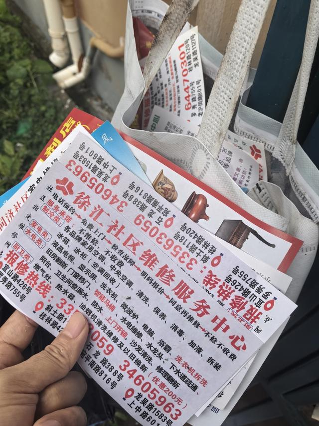 △在东泉路105弄，图上后方挂在信箱上的废纸袋中，能找到五六张电话不同的“社区维修服务中心”小广告。